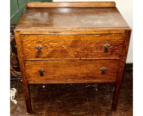 An Art Deco oak chest of drawers, quarter gallery back, caddy top above two drawers, raised on rectangular supports.&nbsp;82c