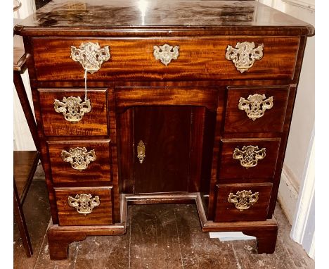 A George III mahogany kneehole desk, circa 1760, fitted with a single drawer to top, a secret frieze drawer below, with three