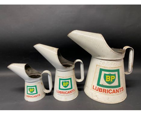 Three graduated BP Lubricants oil measures, gallon, quart and pint.