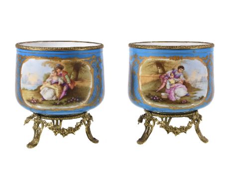A pair of Sevres-style porcelain gilt-metal mounted jardinieres, circa 1900, painted with panels of flowers, supported on gil