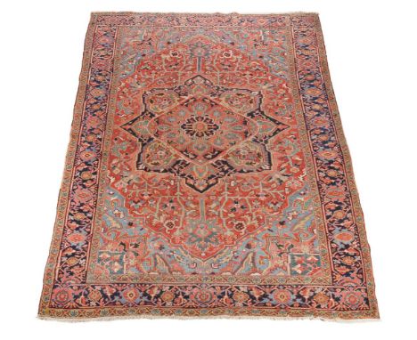 A Heriz carpet, decorated in polychrome throughout, the central medallion cornered by sky blue spandrels, within navy borders