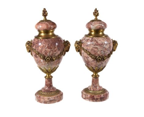 A pair of striated rouge and white marble urns in Neoclassical taste, second half 20th century, each with flambeau finial to 