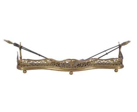 A pierced brass and sheet iron mounted fender, second quarter 19th century, the serpentine front engraved with wyverns amongs