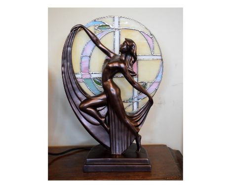 Reproduction Art Nouveau style table lamp with stained glass circular shade behind bronzed Art Deco style dancing figure on s