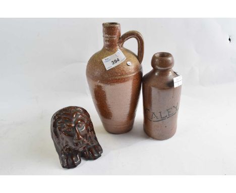 A ginger beer bottle Bourne Denby marked Caley together with a stoneware flask and a treacle glazed model of a lion