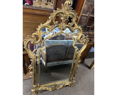 An 18th Century style gilt wood wall mirror with elaborate scrolling and foliate mounted frame, 150cm high
