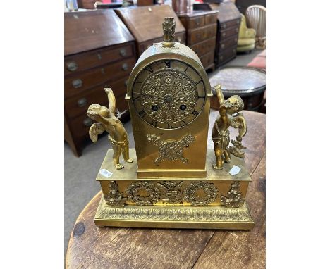 A late 19th Century lacquered brass cased mantel clock of architectural form with two cherub mounts raised on a plinth base, 