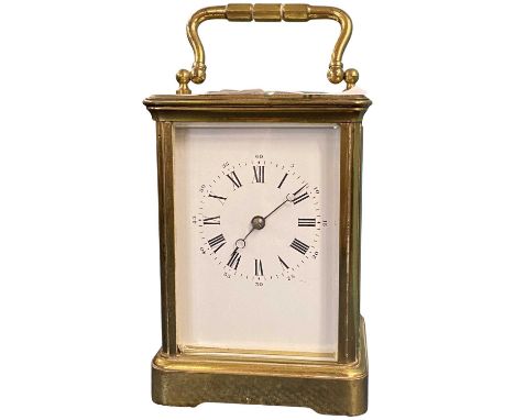 A large early 20th Century brass carriage clock, white enamel dial with Roman numerals, indistinctive inscription to top