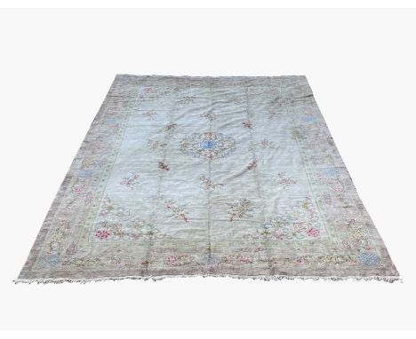 A large Chinese carpet, 20th century, with a central circular floral medallion and floral sprays, 547 x 373cm..