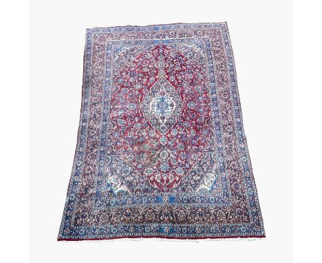 A Meshad carpet, South East Persia, the madder field with a poilychrome lobed pole medallion, within a flowering vine and pal