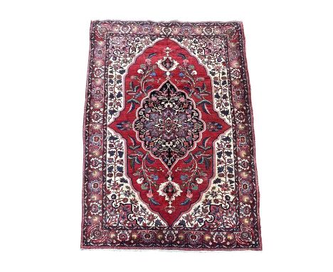 A Baktihari carpet, North West Persia, circa 1920, the madder field with an indigo lobed pole medallion, with flowering leafy