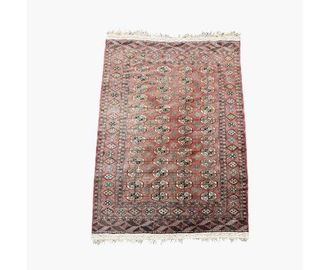 A Tekke carpet, mid 20th century, the madder field, with thirteen rows of four medallions within a sunburst gul border, 275 x