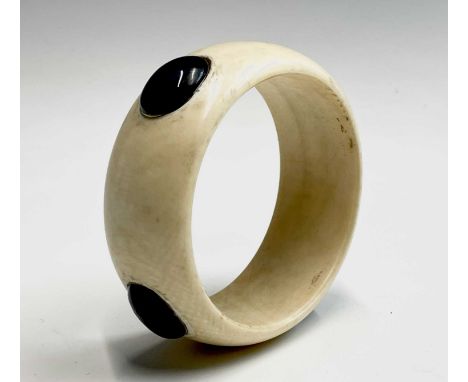 An ivory bangle, circa 1900, with oval set hardstones, inner diameter 6.6cm.