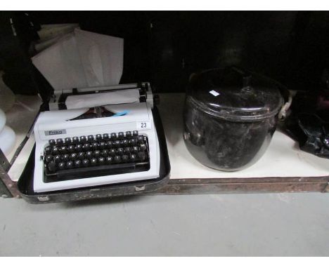 An Erika portable typewriter and an enamel stew pan