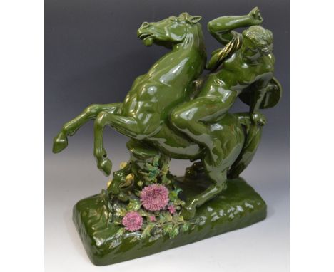 An early 20th century ceramic group,. of a naked Greek female warrior on rearing horse, the base encrusted with flowers, pick