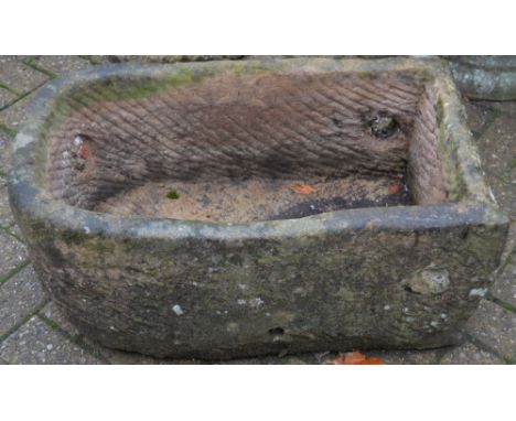 A hewn stone planter, radius to one end. 30cm high x 74cm x 42cm.