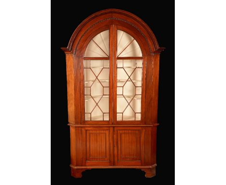 A 19th century mahogany floor standing corner cabinet, arched  cornice, applied with fret, glazed arched astragal glazed door