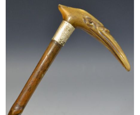 A 19th century walking stick the horn handle carved with a bird's head, glass eyes, silver collar, 82.5cm long