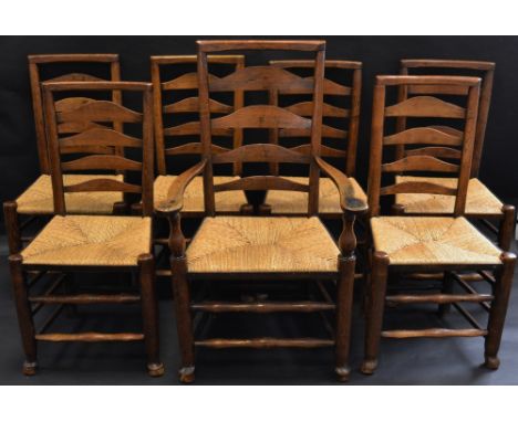 A set of seven 19th century ash ladder back country kitchen chairs, including one elbow chair,  rush seats, turned stretchers