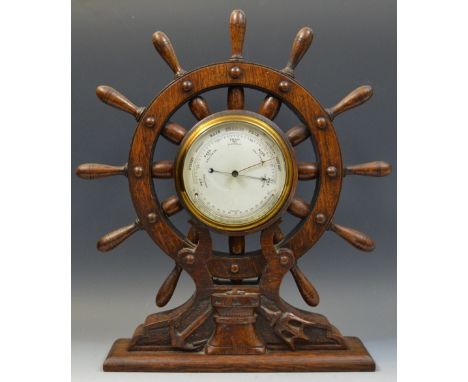 An early 20th century novelty oak mantel barometer, the 11cm circular barometer, mounted into a ship's wheel, rectangualr bas