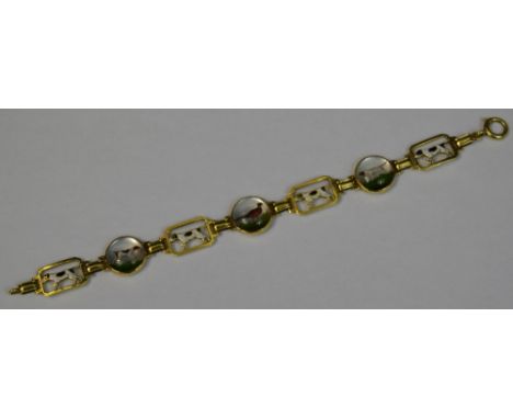 A gold and crystal bracelet,  set with three circular bosses with gun dogs and pheasant, divided  by rectangular panels pierc
