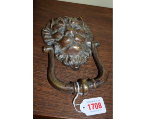 An antique patinated brass lion mask door knocker, 11cm wide. 