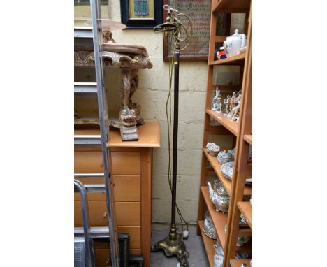 A brass standard lamp, on tripod base. 