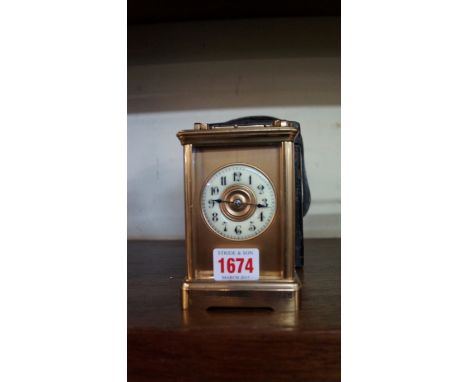 An antique gilt brass carriage clock, with push button repeat and gong strike, height including handle 16cm, with green leath