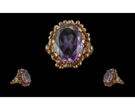 9ct Gold - Attractive Single Stone Amethyst Set Ring, Ornate Setting. Marked 9ct to Shank. The Large Oval Shaped Faceted Amet