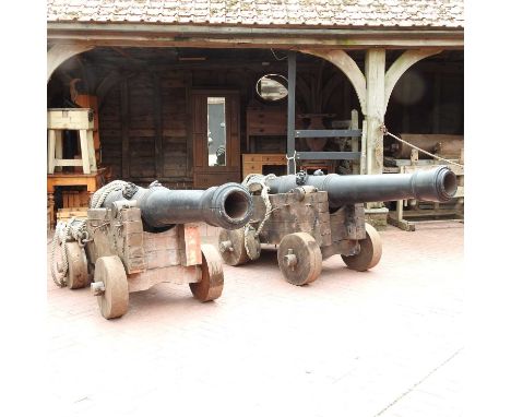 A pair of large replica Tudor ships cannons, on wooden bases. These are thought to have been used as props in the film Elizab