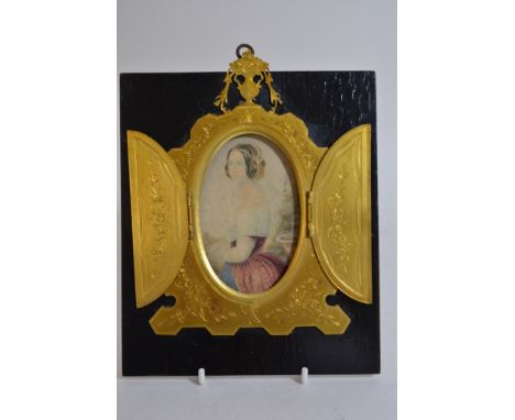 A Victorian brass framed portrait of a young girl.