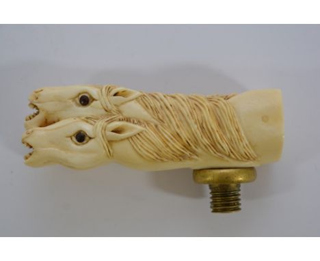 A bone walking stick handle carved as four horses heads