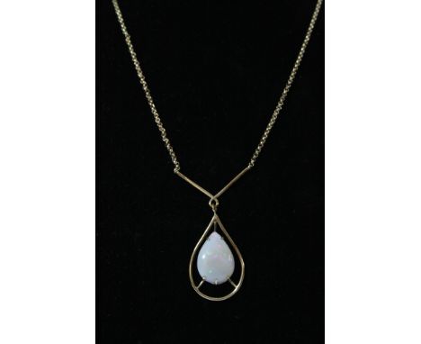 A gold necklace with opal pendant drop
