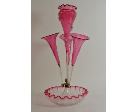 A Victorian cranberry glass epergne with four flutes on a crimped base