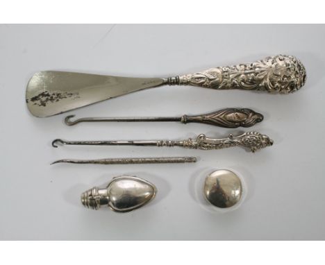 A silver perfume bottle, pill box, shoe horn and three button hooks, various hallmarks.