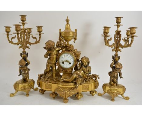 A 19th century French gilt garniture clock set, the enamel dial flanked by cherubs with matching candelabra