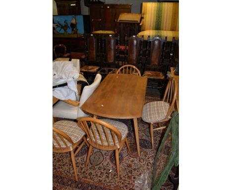 An Ercol lightwood dining table and four conforming chairs