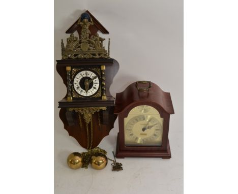 A small reproduction mantel clock and a wall clock with metal figural decoration.