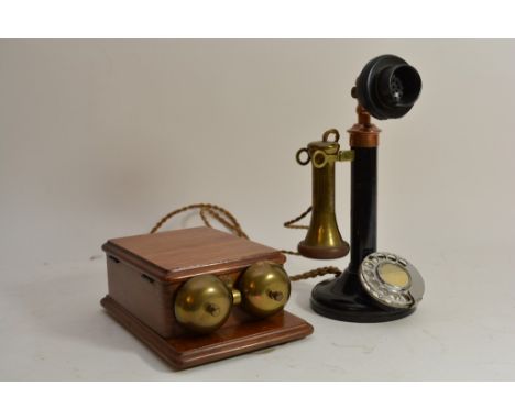 A black stick telephone with wall box