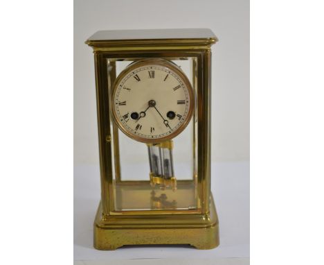 A small brass four glass mantles clock, the enamel dial with Roman Numerals and visible mercury pendulum