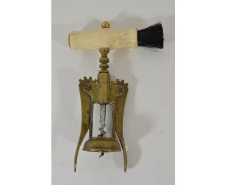 A brass corkscrew with bone and brush handle