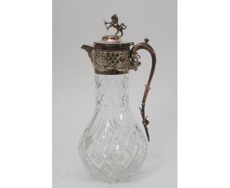 A cut glass decanter with silver plated lid, spout and handle depicting grapes and Bacchus.