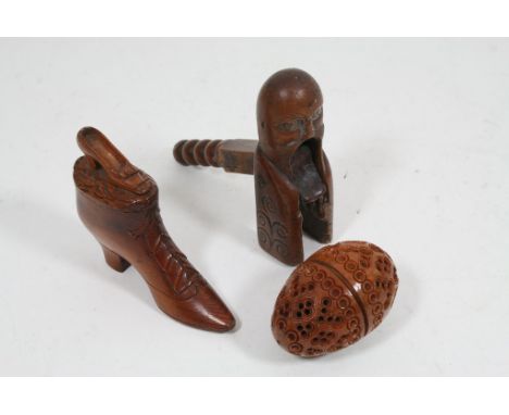 Three treen items comprising a snuff box in the form of a shoe, carved nut and a nutcracker.
