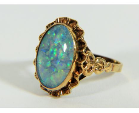 Yellow metal ring (testing 9ct) set with large reconstitued Opal which measures 20 x 14 mm  Finger size 'S5-T'  4.8g