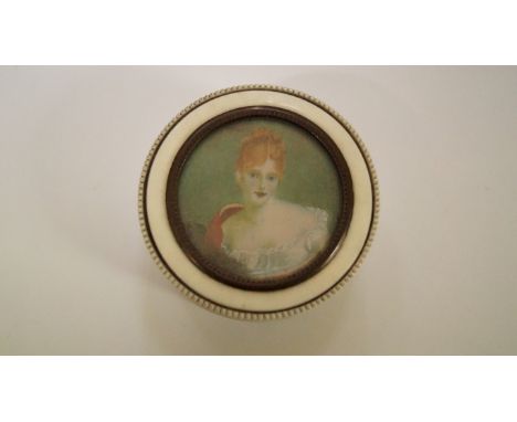 A turned ivory circular box and cover, the cover with a watercolour portrait of a young lady, 6.5cm diameter. 