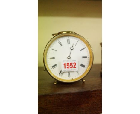 An unusual late 19th/early 20th century brass alarm clock, with an 8.5cm enamel circular dial and repeating on a bell, height