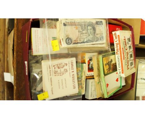 A box of playing cards; together with a small quantity of banknotes; and seven books of gold leaf.
