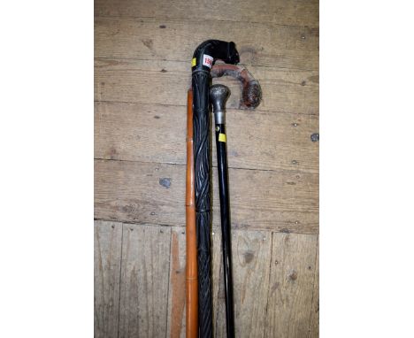 A silver mounted ebonized walking cane; together with another bamboo walking stick; and another ebonized walking stick, (s.d.