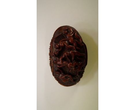 A 19th century carved coquila nut snuff box, the hinged oval top carved in relief with an orgy, 7.5cm wide, (s.d.)