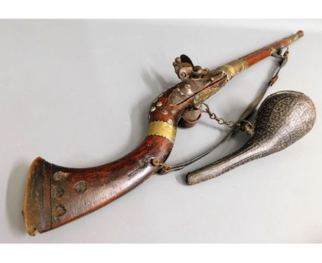 A 19thC. middle eastern flintlock rifle with powder flask, 42in long